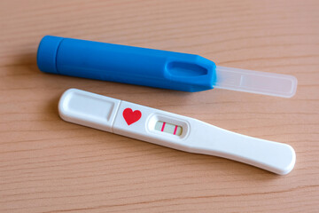 Positive Pregnancy Test with Red Heart Symbol on Wooden Surface &ndash; Two Lines Result