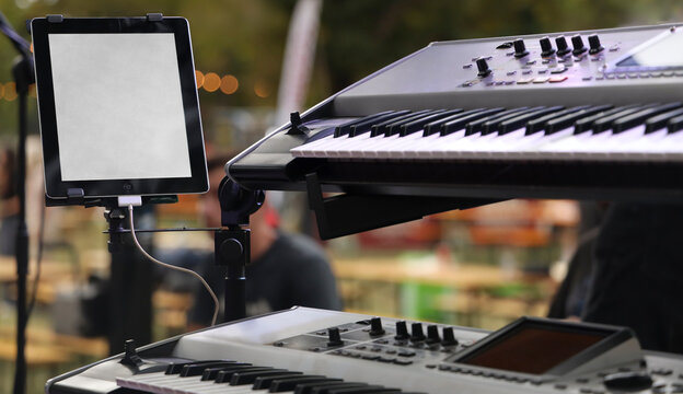 double Synthesizer on a Concert Stage near Kalemegdan fortress electric Music concert Lyrics on screen of tablet. Belgrad, Serbia