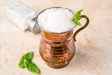 Turkish buttermilk in a copper cup on vintage stone table. Turkish yogurt drink