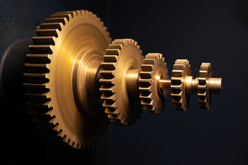 Brass Gears in a Row on Dark Background metal mechanical