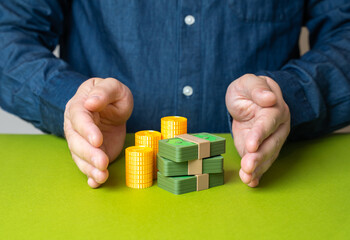 A man protects money with his hands. Preservation of capital. Safe investments. Savings security,...