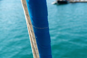Blue sail cover with rope on sailboat close-up