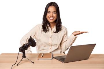 Woman records podcast with laptop showing a copy space on a palm and holding another hand on waist.