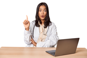 Young Filipino doctor with laptop in studio having some great idea, concept of creativity.