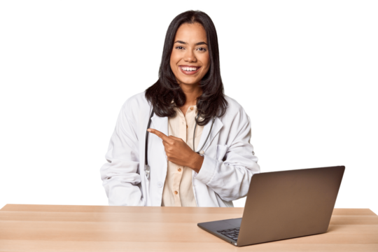 Young Filipino doctor with laptop in studio smiling and pointing aside, showing something at blank space. - Powered by Adobe