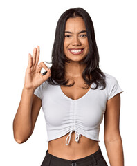 Young filipino woman cheerful and confident showing ok gesture.