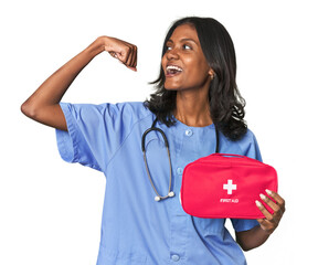 Young Indian nurse with first aid kit raising fist after a victory, winner concept.