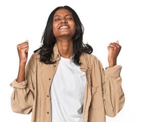 Portrait of a young Indian woman celebrating a victory, passion and enthusiasm, happy expression.
