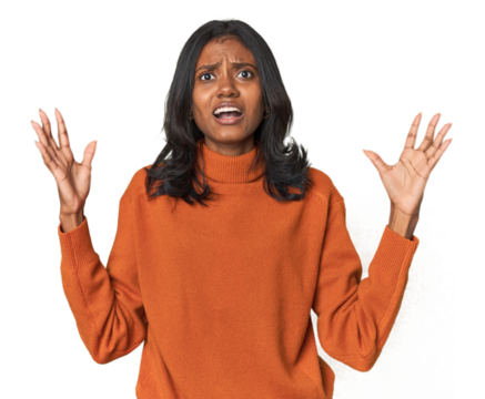 Portrait of a young Indian woman screaming to the sky, looking up, frustrated.