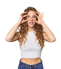 Simple redhead studio portrait points sideways, is trying to choose between two options.