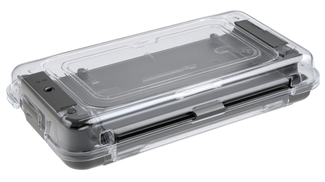 Clear protective case for a handheld electronic device.  The case is transparent, showing the device inside.  Dark gray components are visible.  The case has a flat top and is rectangular