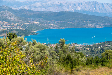 Blue bay with sailboats and surrounding mountains