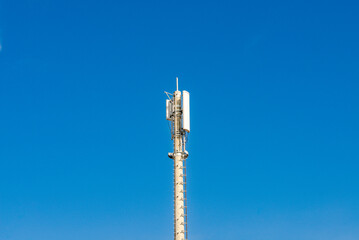 Telecommunications tower top section against blue sky