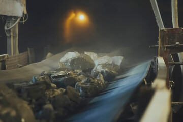 The stones of the ore crushed in stone crusher are coming through the belt. Screen in a gold mine