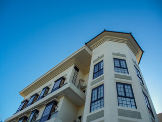 Obraz premium Exterior of building with elements of Art Deco or Mediterranean Revival architecture with clear blue sky background, low angle shot.