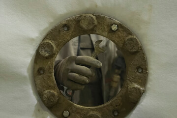 Screw the stud and nut with your hand when attaching the flange to the wall of container.