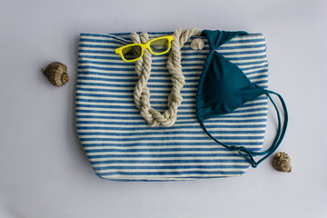 photo background beach striped blue and white bag, sunglasses on a white background, shells, sea,...