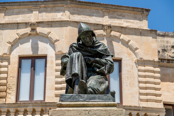 Obraz premium Seated bronze statue in front of historic facade