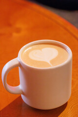 Warm cappuccino in a cup with heart-shaped latte art on top