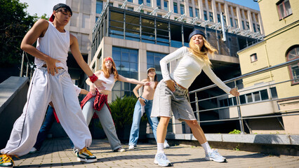 Urban street dancers moving with intensity and confidence in dynamic outdoor style. Concept of...
