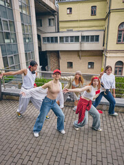Street dancers showing unity and confidence with expressive urban movement outdoors. Concept of youth culture, dance and music, fashion creativity, lifestyle promotion and social media.