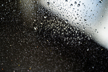 background texture for background with water drops in black, brown and gray, with shimmering elements and dripping drops on glass, beautiful bright background with overflows and gradient in slight blu