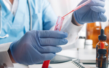 Scientist Pipetting Red Liquid into Test Tube in Lab. Close-up of a scientist in a lab coat,...