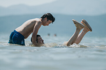 Two young friends laugh and splash in a tranquil lake, engaging in playful activities. The natural tones of the water and surroundings enhance the relaxed summer outdoor atmosphere.