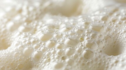 Fototapeta premium Close-up creamy foam texture with glistening bubbles, perfect for beverage or dairy advertising