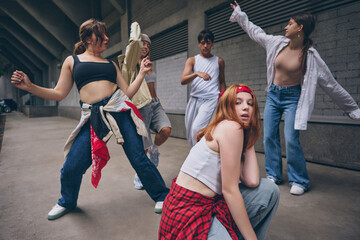 Redhead dancer posing in front with dramatic emotion during group street dance. Concept of youth...