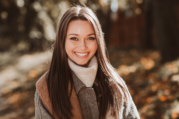 Portrait of a young woman in an autumn setting, showcasing her elegant style and gorgeous...