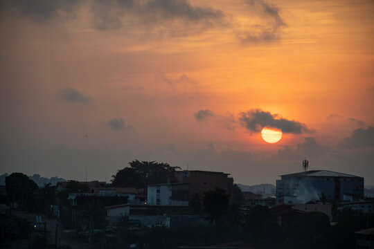 Sunset over the rooftops of Abidjan &ndash; Urban silhouettes and blazing sky