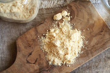 A heap of whey protein powder on wooden background