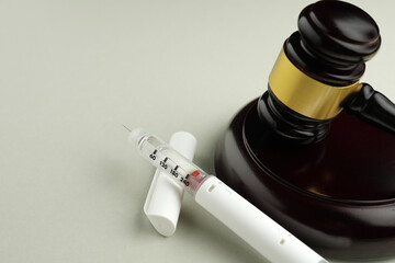 Semaglutide injection pen with judge gavel – legal and ethical debate in medicine