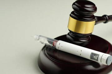 Semaglutide injection pen with judge gavel – legal and ethical debate in medicine
