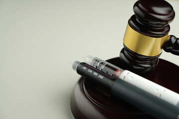 Semaglutide injection pen with judge gavel – legal and ethical debate in medicine