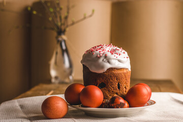 beautifully decorated Easter cake topped with icing and sprinkles sits among bright red and...