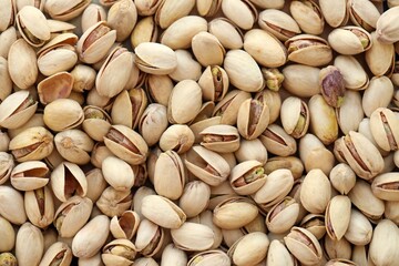 Tasty unpeeled pistachios as background, top view flat lay background