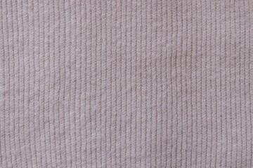 Texture of knitted pastel pink sweater, close-up texture of beige pink