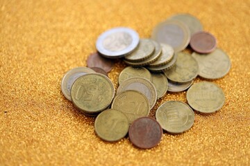 Big amount of euro coins on golden glitter background