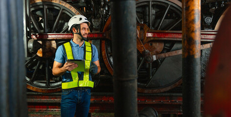 man in  safety vest is standing in front of  train engine