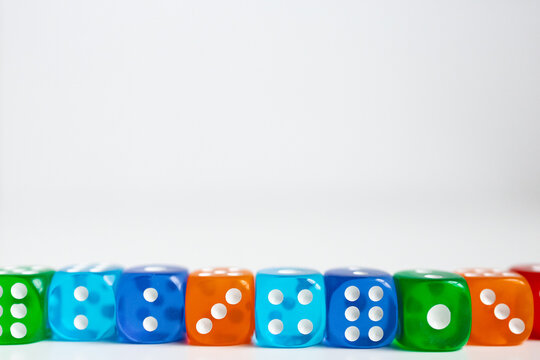 Colorful assortment of dice arranged in a row on white background - Powered by Adobe