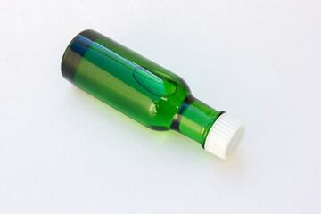 A green bottle of eucalyptus oil with white cap, isolated on white. Eucalyptus oil supports a healthy lifestyle by offering benefits such as respiratory relief, pain and inflammation reduction.