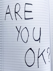 A simple handwritten question 'Are you ok?' in a notebook, a powerful symbol for mental health awareness, support, and empathy
