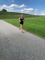 young woman running on the road nature