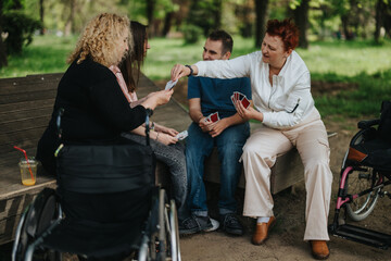 Outdoor gathering featuring friends playing cards together surrounded by nature, illustrating...