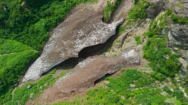 糸魚川市の権現岳に残る「柵口の万年雪」の全景を夏に撮影