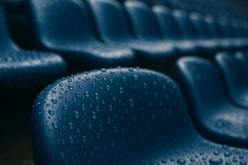 Obraz premium Wet Stadium Seat Macro Raindrops Texture Symbol of Sports Environment Outdoor Weather