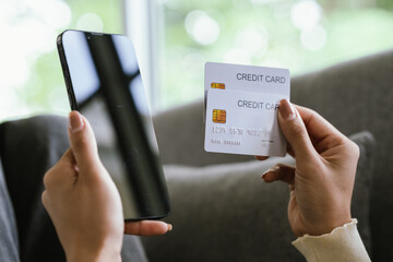 A young woman uses a laptop and credit card for online shopping, symbolizing modern finance, digital payments, e-commerce, banking, and technology-driven consumer lifestyles in today’s connected world