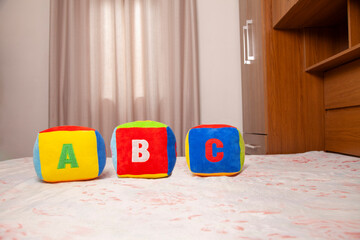 Children's plush dice with the writing A B C.
